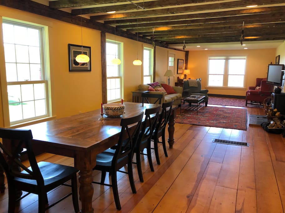 The renovated, open living area includes dining room with a custom table for 8-12, living room, and sitting area
