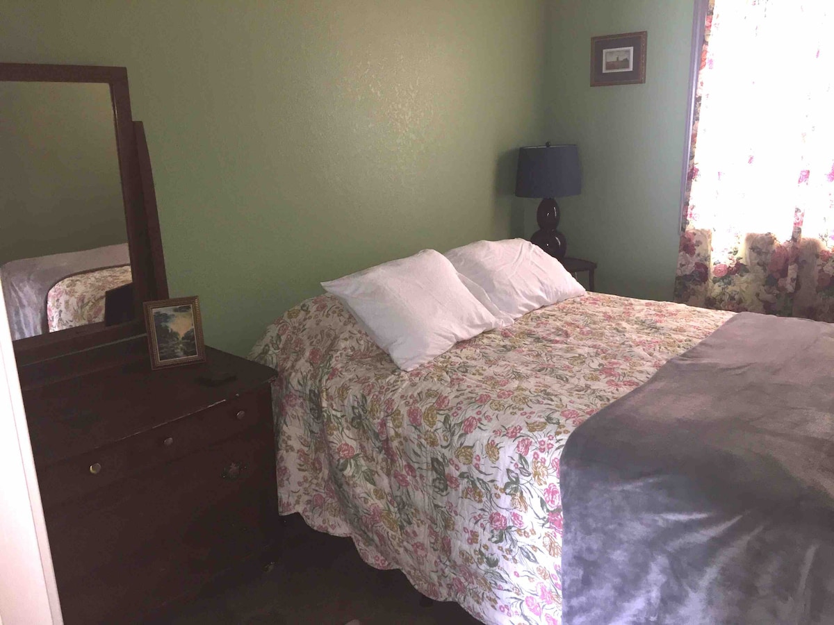 Das Schlafzimmer im Erdgeschoss bietet ein Queensize-Bett, eine Kommode und einen Kleiderschrank.