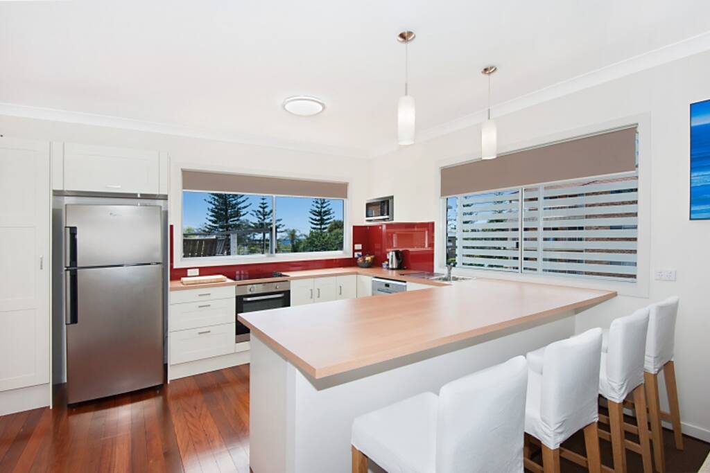 Full kitchen including fridge, microwave, breakfast bar, stove top and oven, dishwasher, kettle, coffee machine, cutlery and crockery.