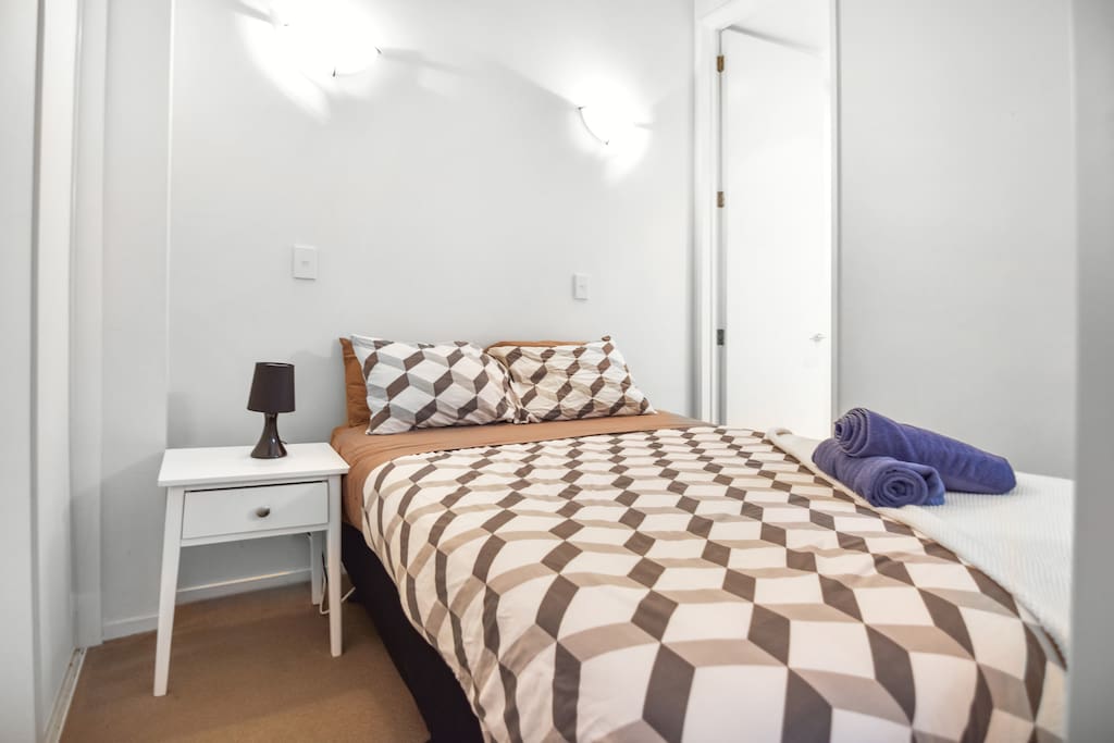 A bedroom with a double bed & plush pillows.