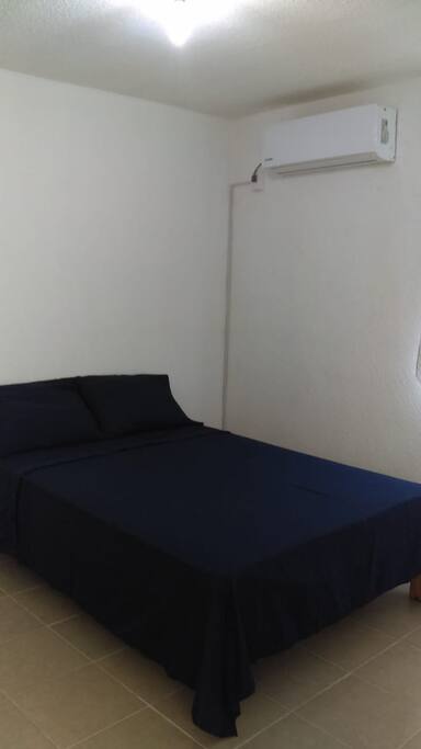 Recámara con cama matrimonial, closet y aire acondicionado.