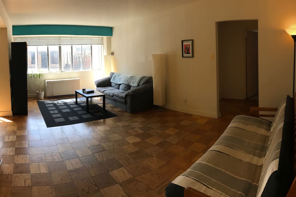 Large living area with comfy couch, big screen TV and futon.