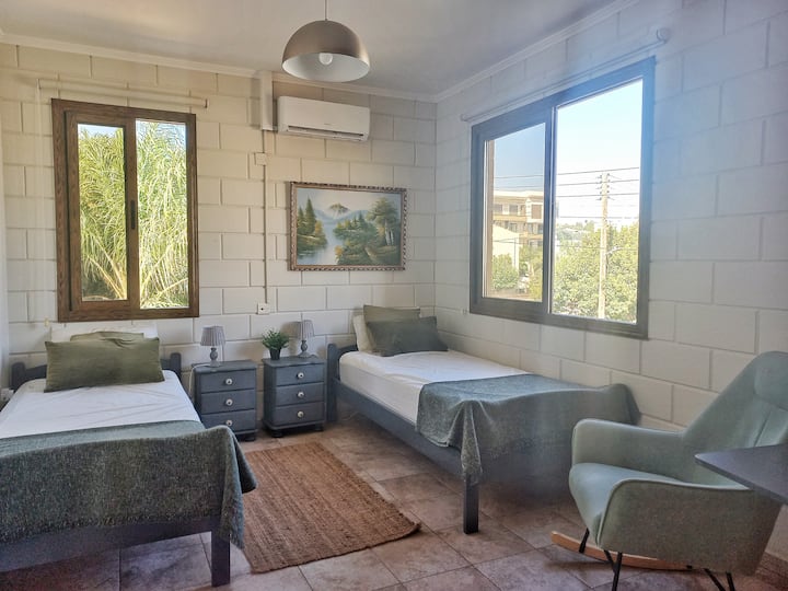 Мечтателна спалня с 2 единични легла, голям гардероб и кресло.