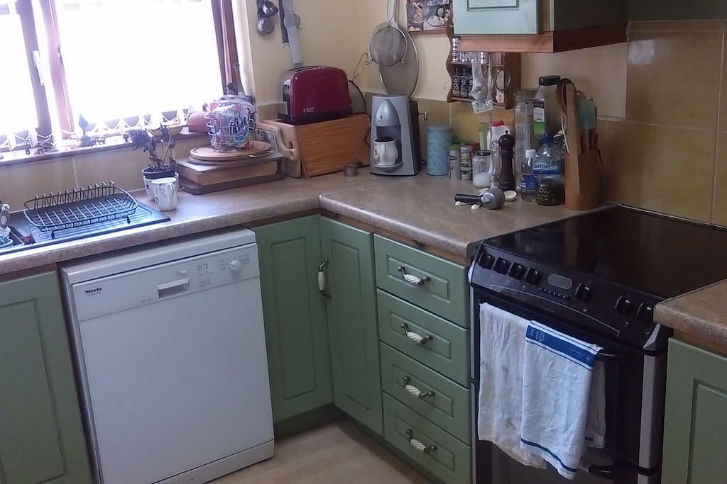 A fully equipped kitchen includes electric cooker, dishwasher, fridge and freezer, microwave, cooking implements, kettle and toaster.