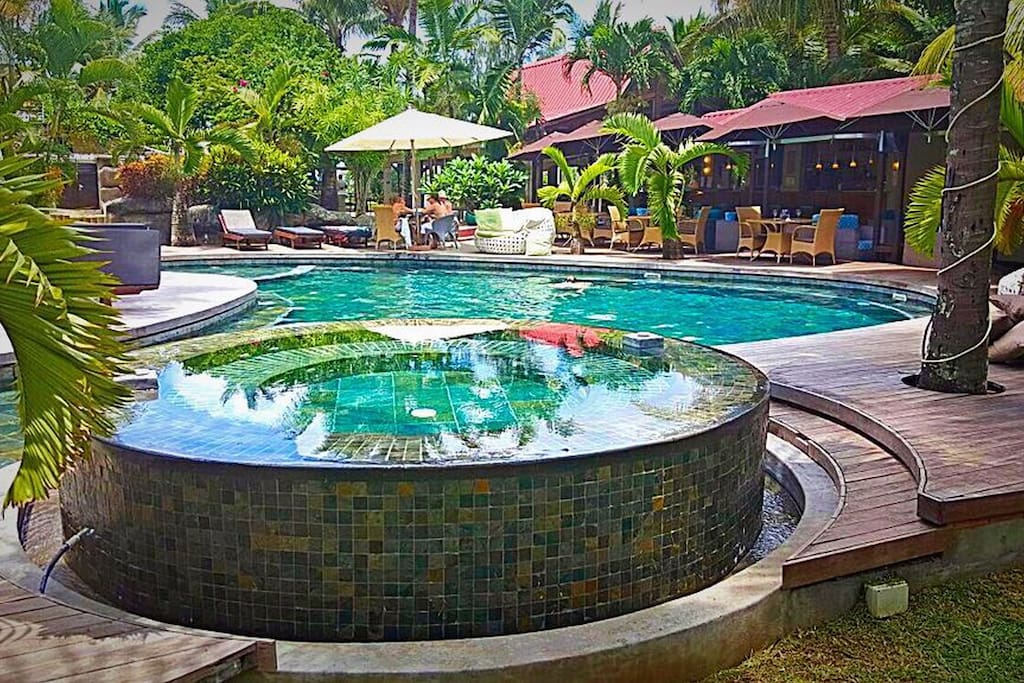 Swimming pool with seating area around within the pool.