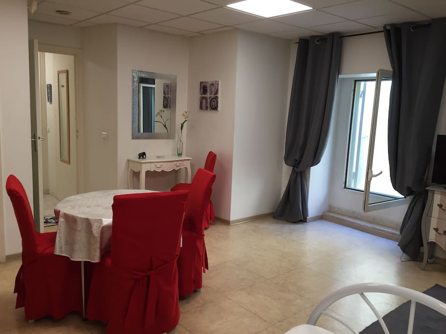 Grand salon, table à manger, accès à la cours privative par la porte-fenêtre