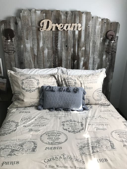 Full size bed, with real rustic wood headboard and dimmable bedside lamps.