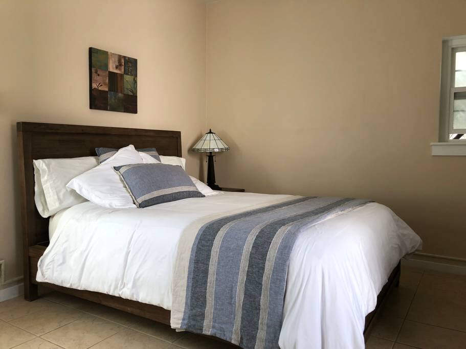 Queen size bed with lots of pillows and blankets. Bright living space!