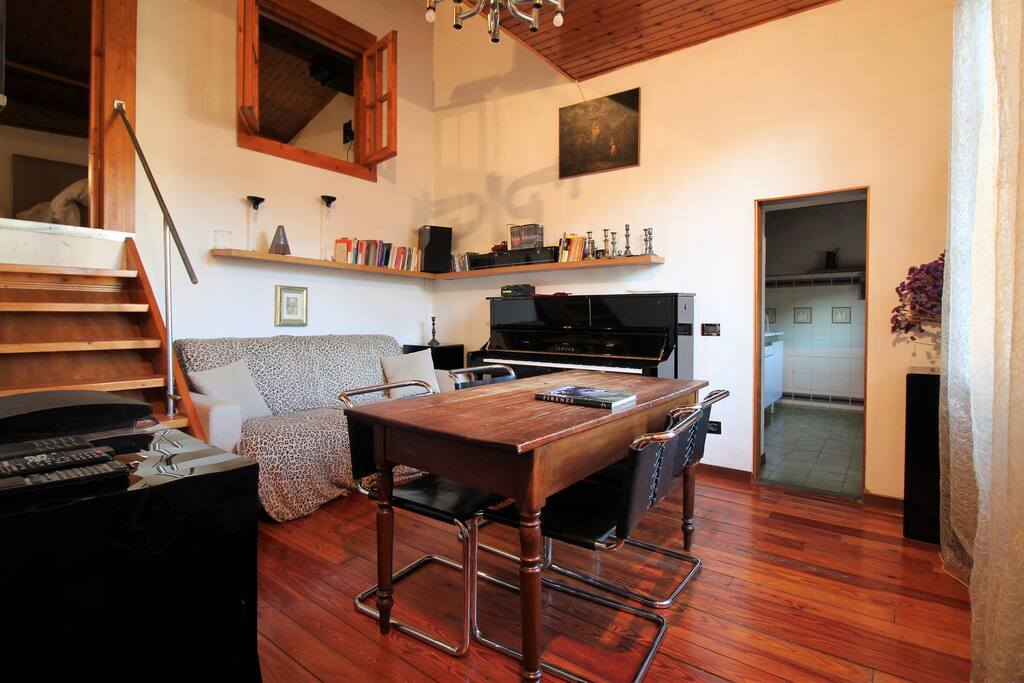 The living room with the beautiful piano and the sofa bed