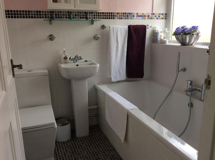 Beautiful bathroom with mineral hair shower as well as overhead shower, jacuzzi bath,  and washbasin. Good selection of shampoos, conditioners and shower creams