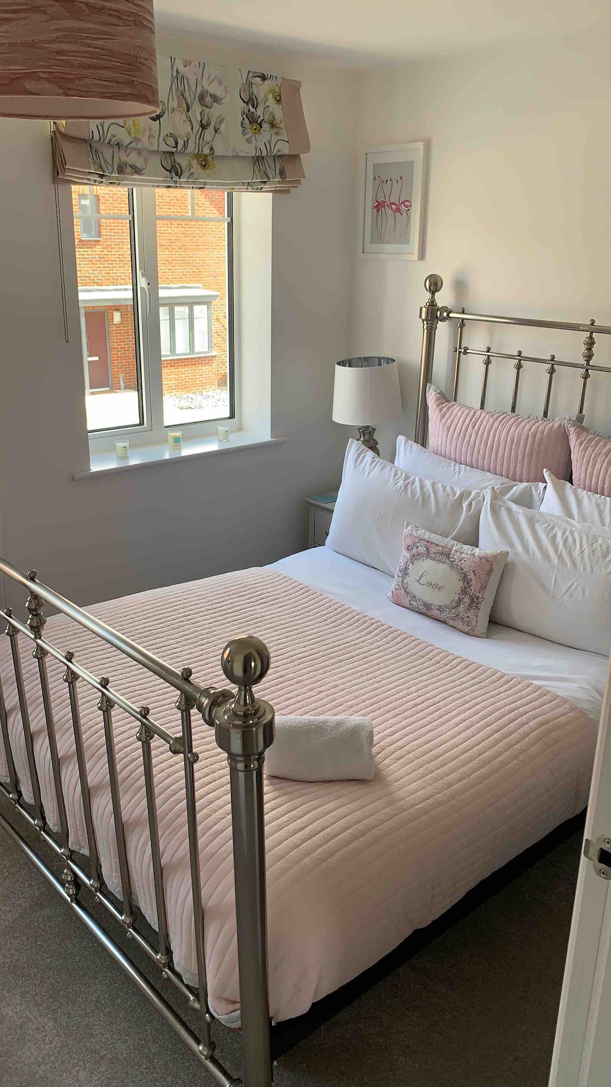 Cama doble con lujosa ropa de cama blanca de la empresa. 