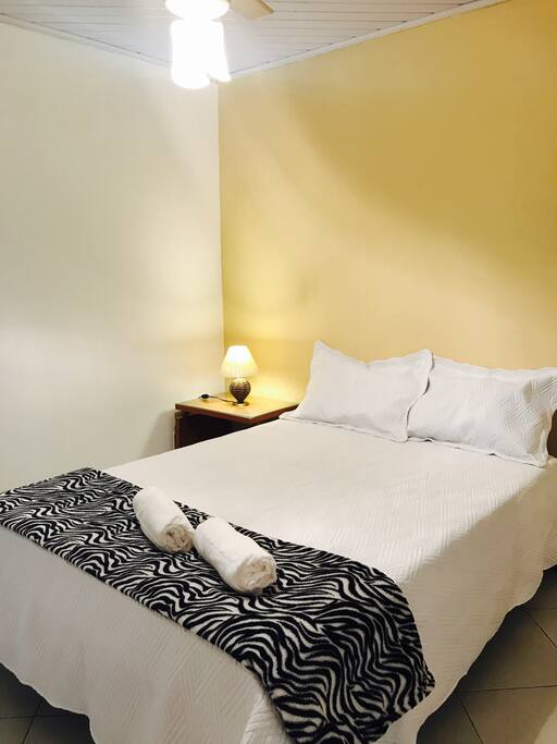 Suíte com cama matrimônial, ar condicionado mais ventilador de teto.