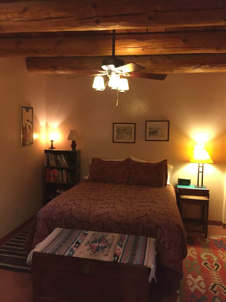 ห้องนอนมีเตียงควีนไซส์พร้อมตู้เสื้อผ้าขนาดใหญ่และตู้หนังสือที่มีอุปกรณ์ครบครัน