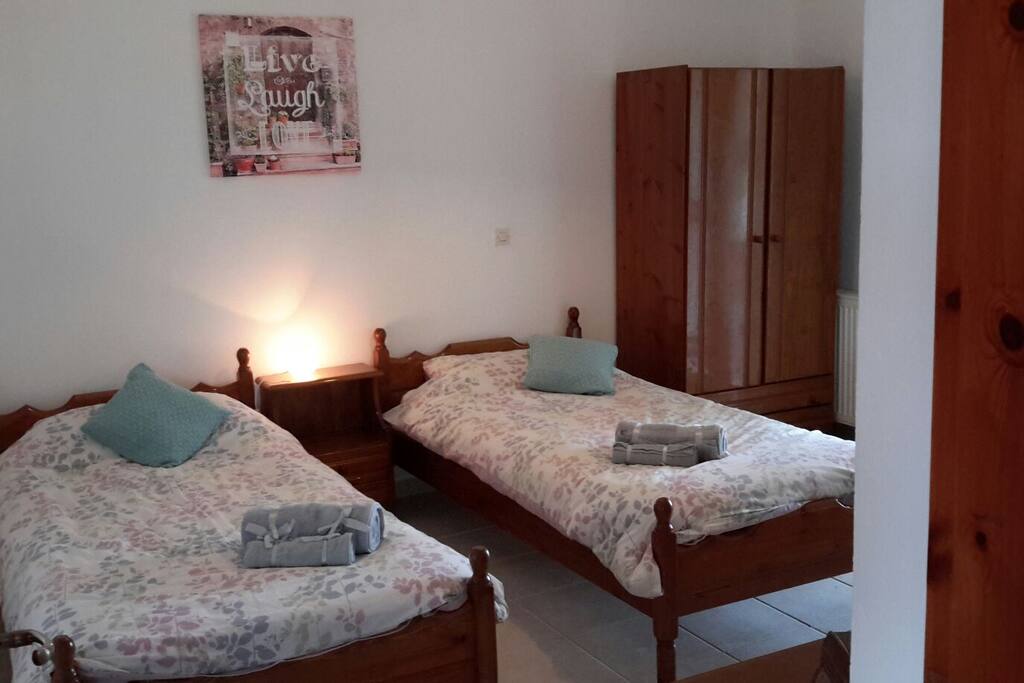 Ground floor bedroom with 3 single beds next to bathroom with toilet and wet room type shower