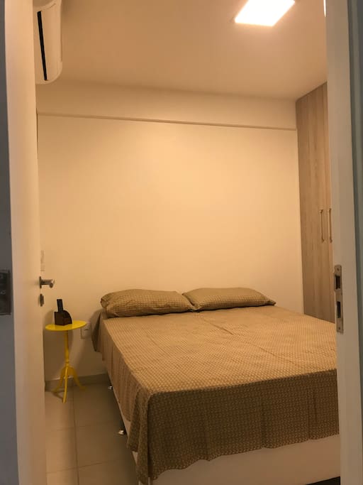 Quarto casal com cama, ar condicionado, guarda roupa e TV 32 polegadas.