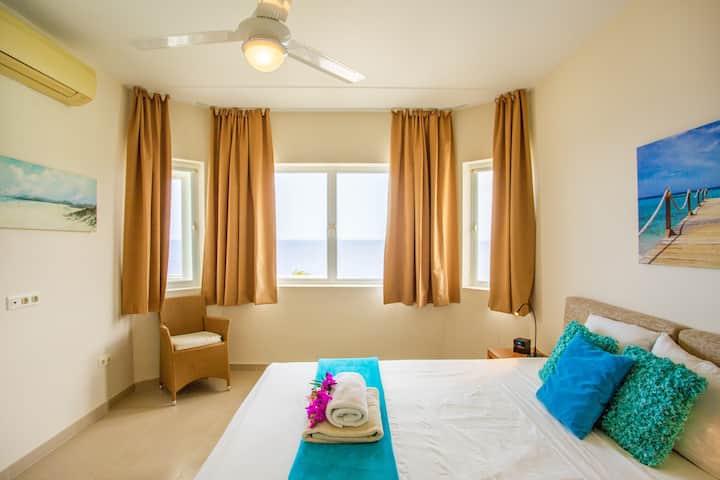 The 2nd bedroom has a king size bed, sea view, air conditioning, a private bathroom, ceiling ventilator and screens for the windows.