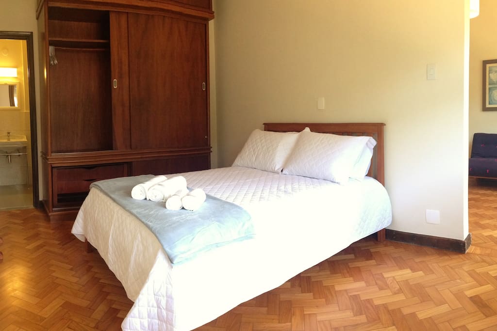 Quarto com cama de casal, armário e ar refrigerado