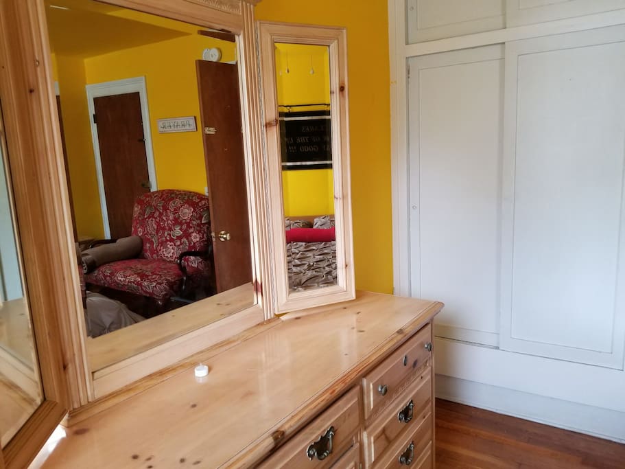Bedroom has dresser with mirrors
