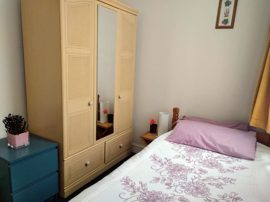 The room is bright and comfortable with a table and cupboard space