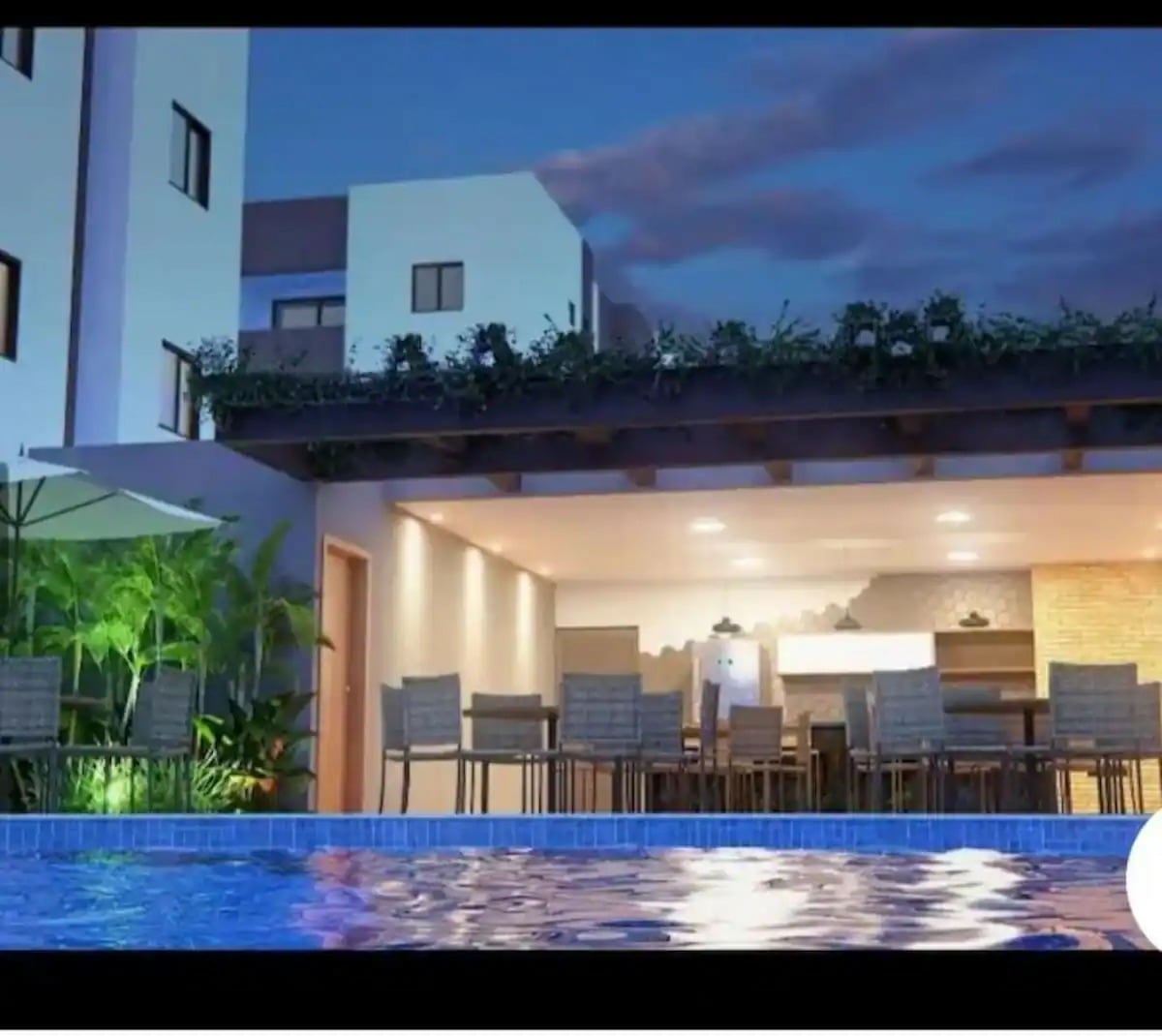 An outdoor dining area is featured with multiple chairs surrounding a large table, under shaded eaves. Soft lighting creates a welcoming ambiance. The scene includes a refreshing pool in the foreground, reflecting the evening sky, framed by lush greenery and modern architecture.