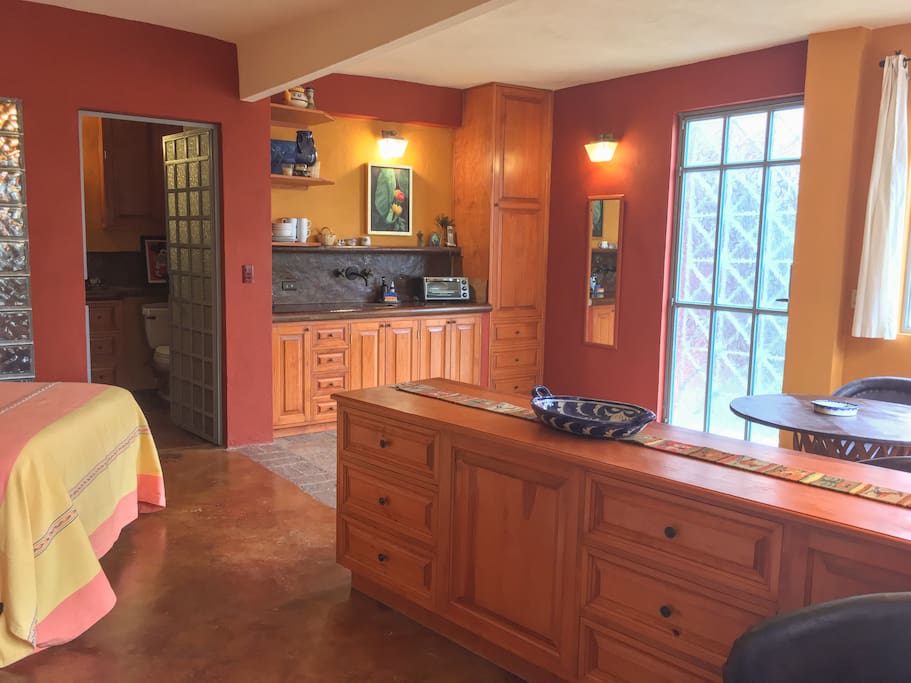 Bed to the left, kitchenette straight ahead, bathroom door to the left of the kitchenette, entry door to the right the kitchenette. Small refrigerator under the cabinet, hot plate, coffee maker, toaster oven and full set of plates and utensils and accessories included, closet with hangers to the right.