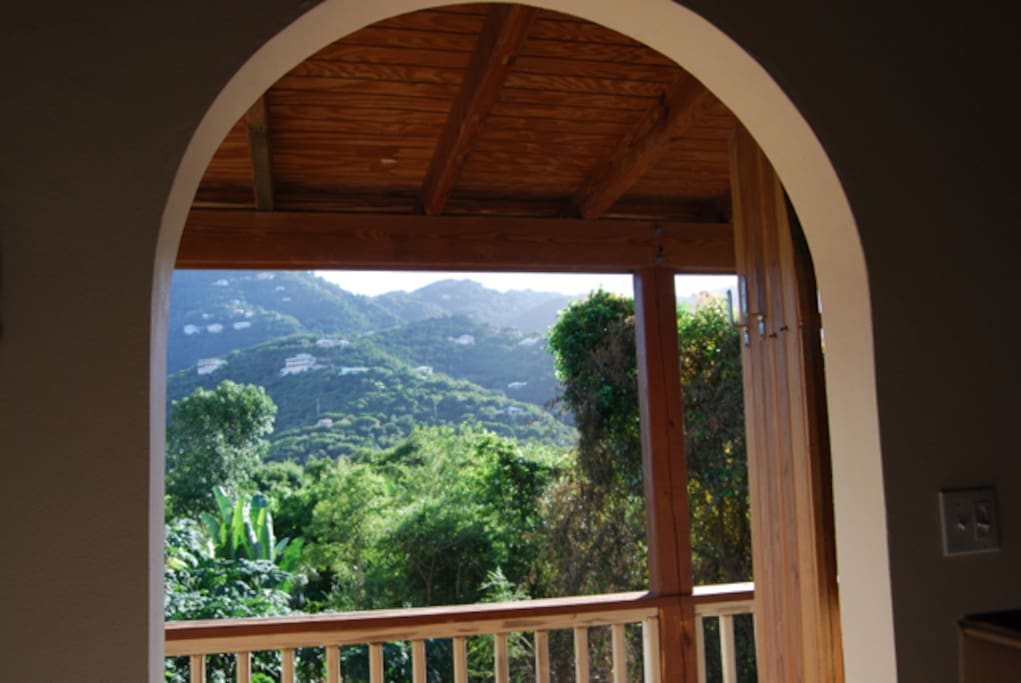 Ached door frames look out Coral Bay's the lush hillside.