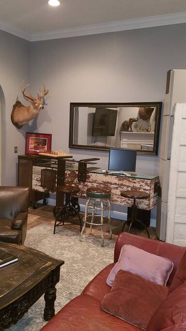 handmade unique barn door and rod iron computer and gaming area located in a common area on the living room.