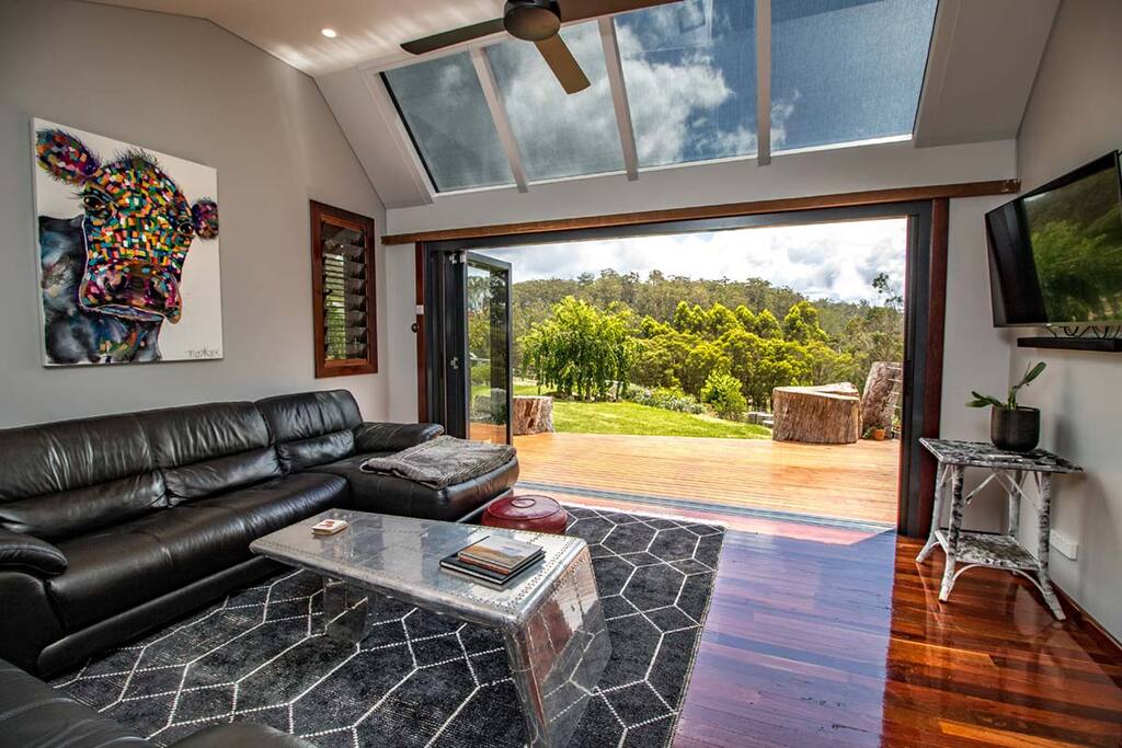 Sun room wit bi-fold doors and potbelly. TV and bluetooth sound bar for entertaining
