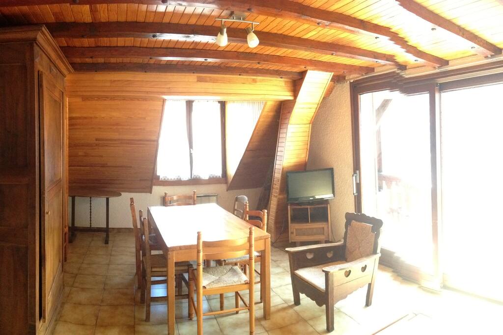 Pièce principale de l appart avec un coin repas ,un coin salon avec clic clac et le balcon.