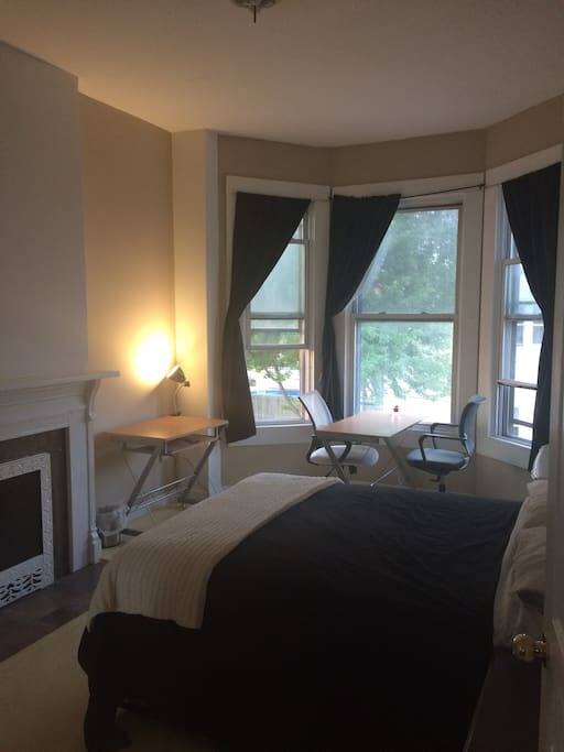 Bedroom with high ceiling and sealed fireplace