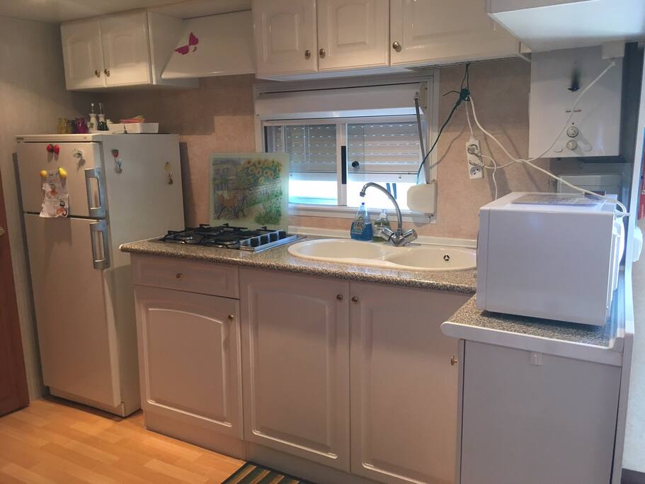 Cuisine équipée avec un frigo et une partie congélateur, micro ondes, cafetière, vaisselle, rangement avec des indispensables (sucre, café...) pour accueillir nos hôtes agréablement.