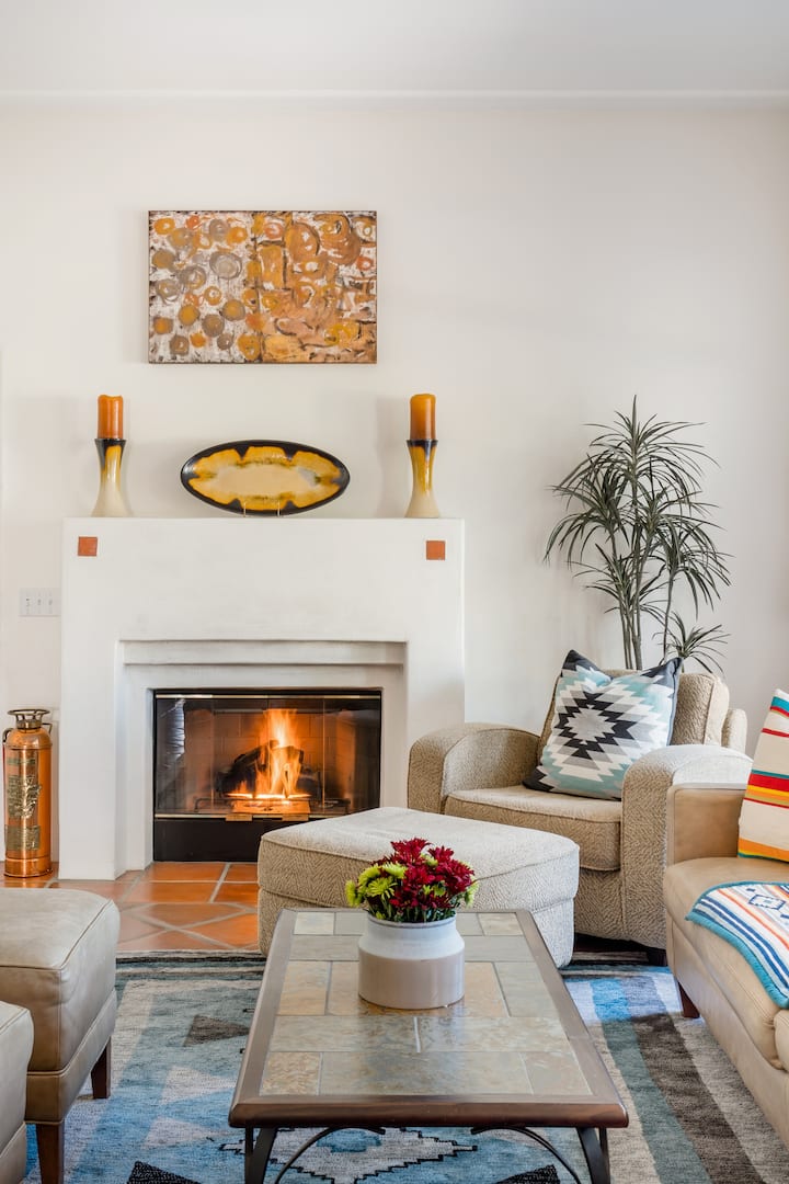 استمتع بالدفء بالقرب من المدفأة ، واسترخ في منطقة المعيشة الجميلة ذات الأسقف العالية