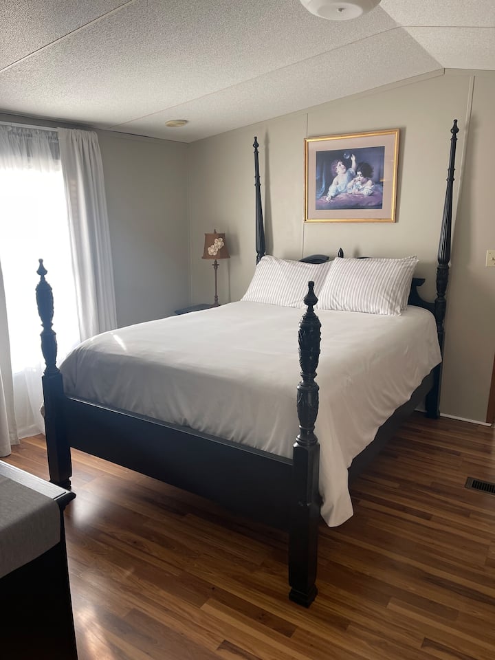 Split Master Suite Queen Bed so zatemňovacími závesmi, komodou a šatníkom