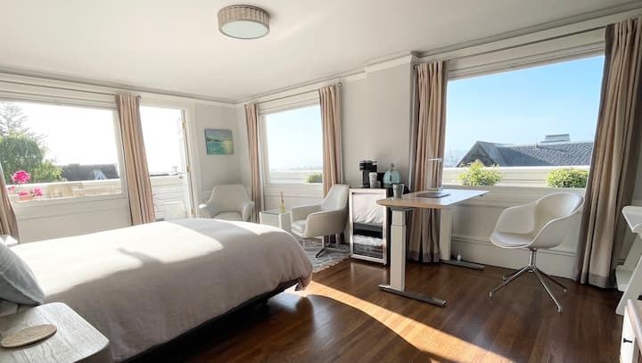 Penthouse suite grote slaapkamer en werkstation bekeken vanaf de ingang. 