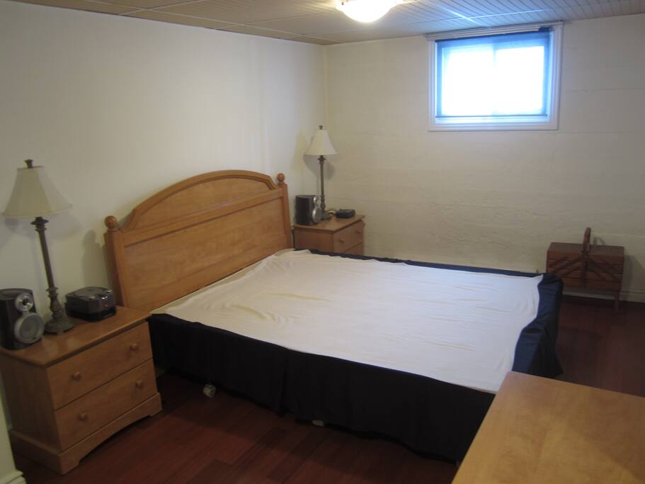 Chambre avec lit queen, commode et garde-robe walk-in.