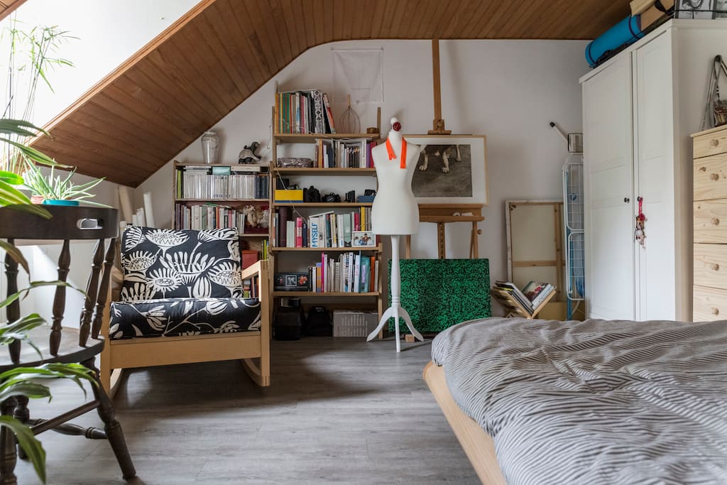grande chambre avec lit, petit espace bureau, bibliothèque.