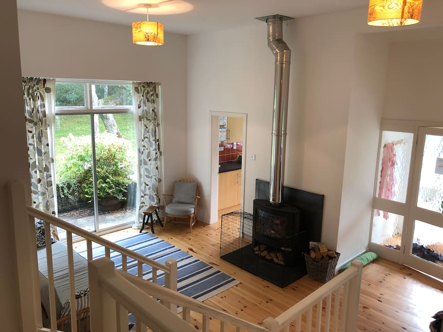 Downstairs sitting room with new woodburner. View from upstairs landing showing the open plan sitting room through to dining area and access to kitchen.