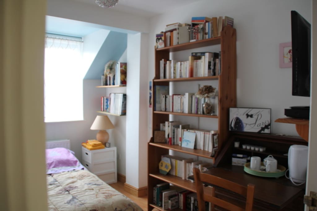 The bedroom with French, English books, a desk, a kettle, a TV and DVD player
