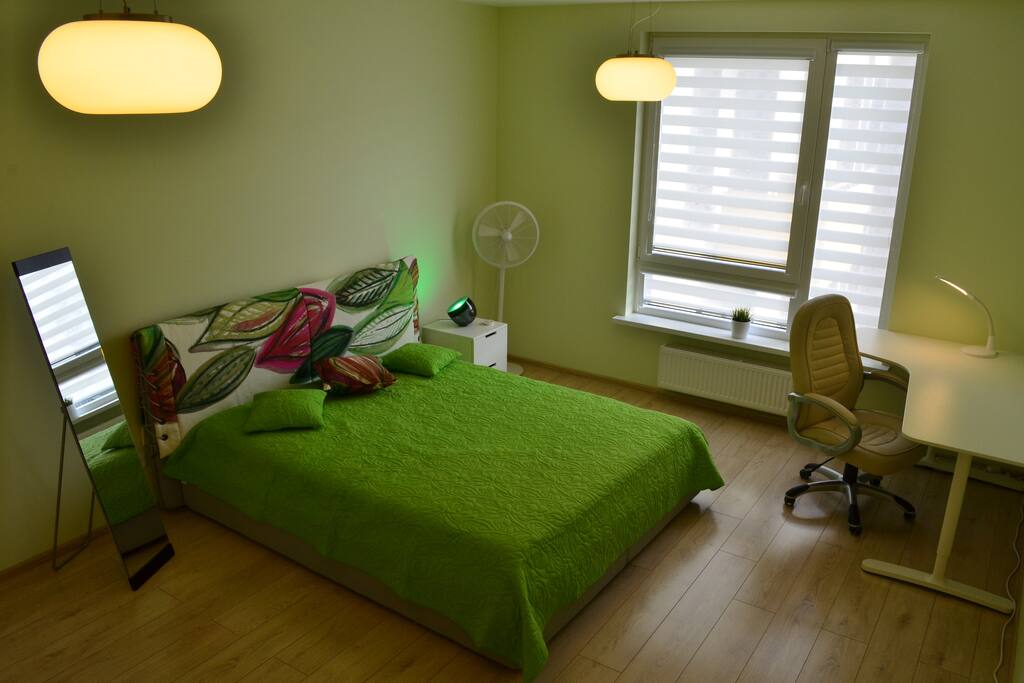 Bedroom with comfortable queen-size bed, silent fan and workplace.