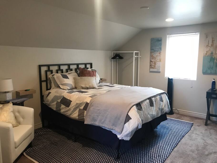 Queen sized bed, reading area, and open wardrobe