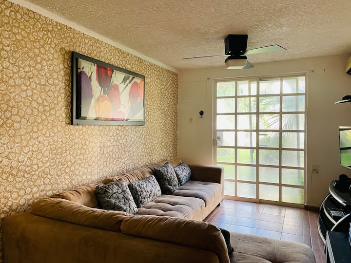 宽敞舒适的客厅，位于一楼，配有基座风扇，您可以通过水晶门进入泳池和花园。 