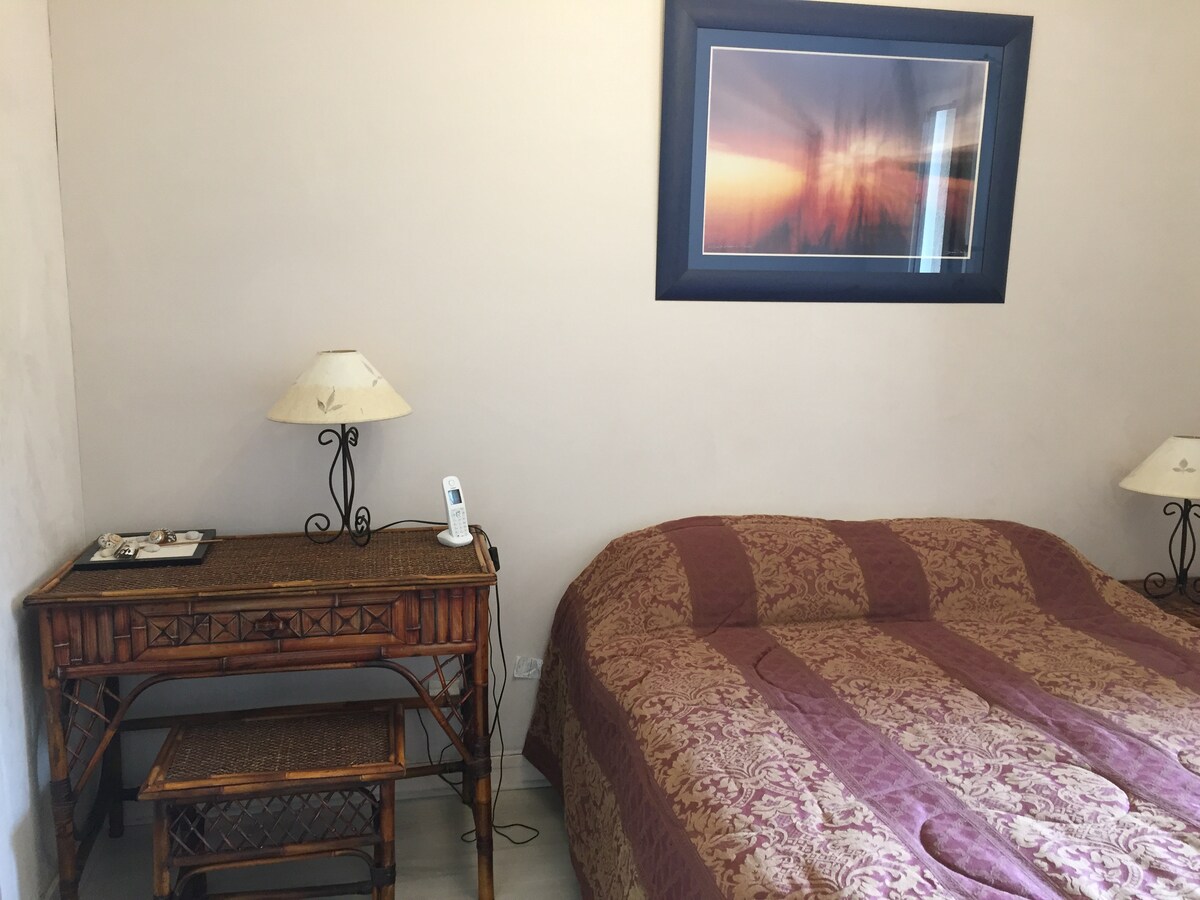 חדר שינה עם מיטה זוגית וחדר רחצה צמוד