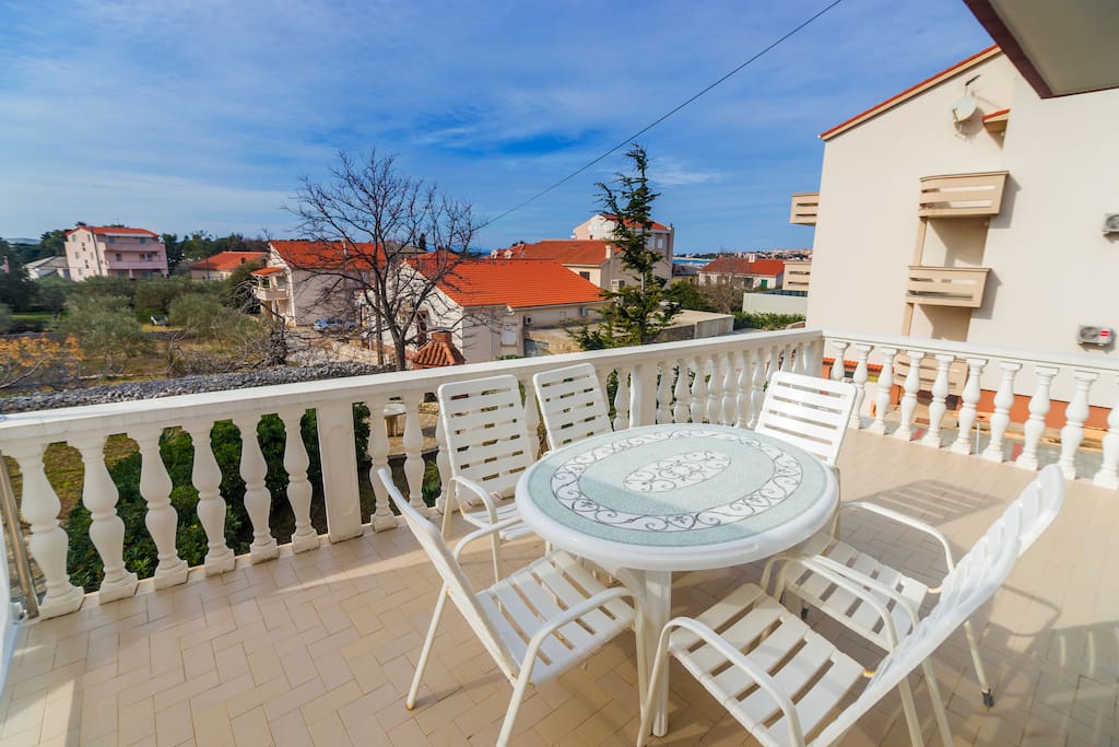 Apartment has a balcony with table and chairs