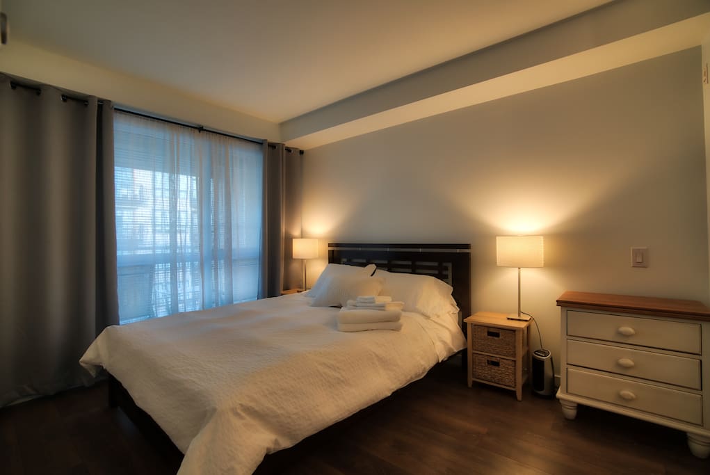 Spacious bedroom with blackout curtains, premium linens