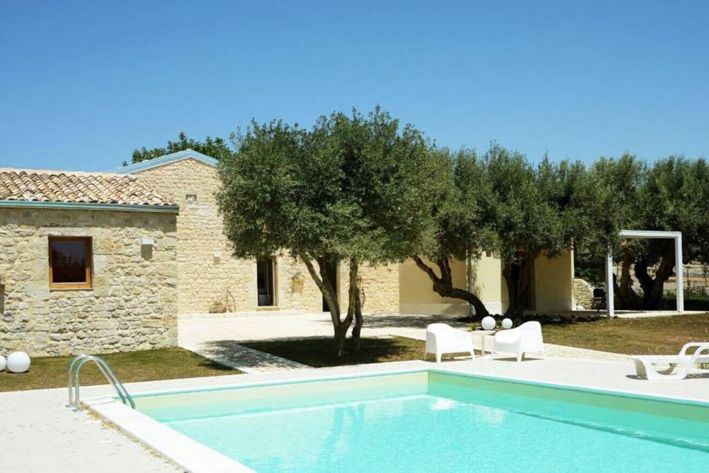 Zona piscina, attrezzata di poltrone, sdraio, ed ombrelloni.