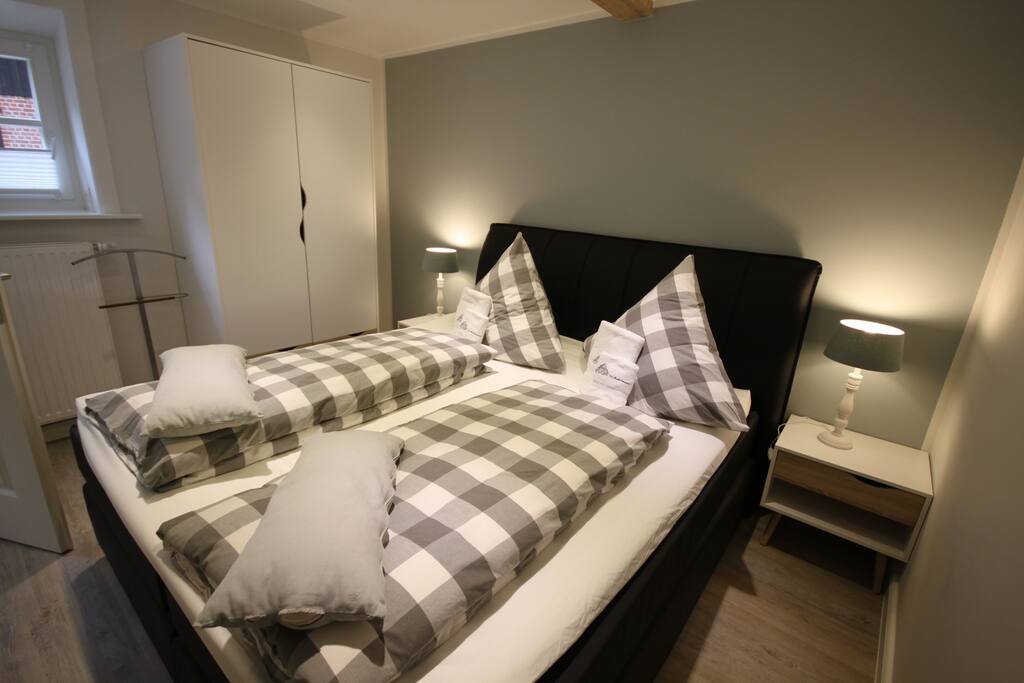 Schlafzimmer mit Boxspringbett und Fenster zum Hof
