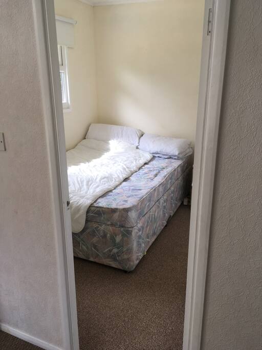 Small double bedroom includes a wardrobe and small set of drawers