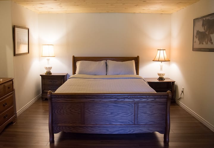 Dormitorio queen con puertas francesas que se abren a la vista del bosque