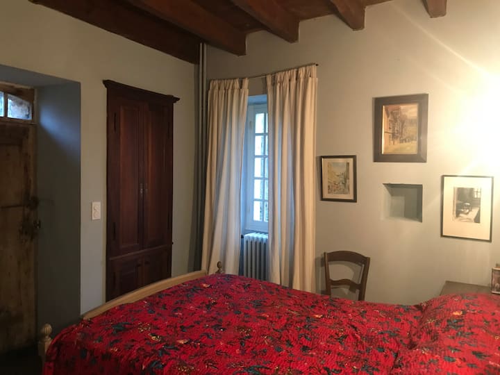 
Chambre principale avec lit double, lavabo dans le placard et porte donnant sur le patio du premier étage.