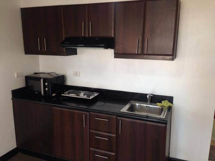kitchen comes with microwave, induction cooker, rice cooker, range hood and assorted cooking wares